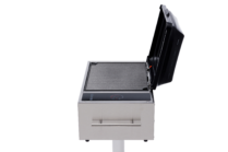 side view of Stainless steel built-in electric grill with a black lid and touch controls, mounted on a post against a black background.
