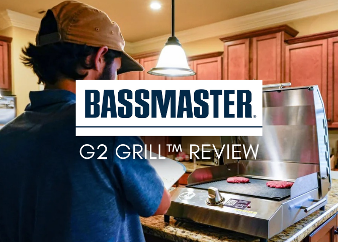A man in a baseball cap grills burgers on the Kenyon G2 Grill in a kitchen, with a 'Bassmaster G2 Grill Review' title overlay.